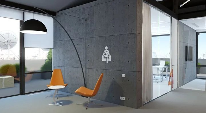 Waiting area of a modern office with concrete walls, large windows and orange chairs